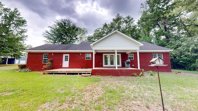 back of house with a deck, brick siding, french doors, and a yard