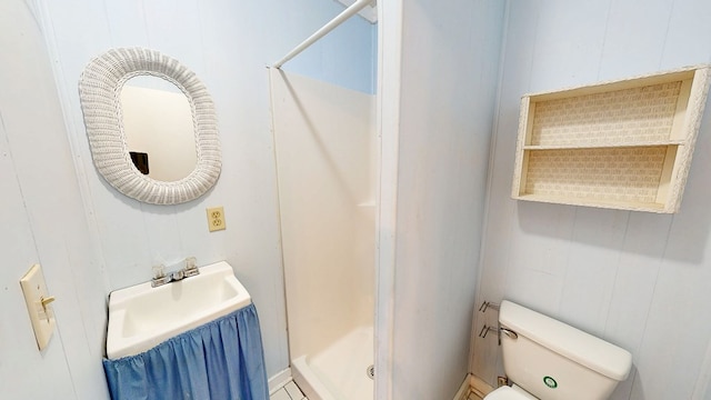 full bath featuring toilet, a shower stall, and a sink