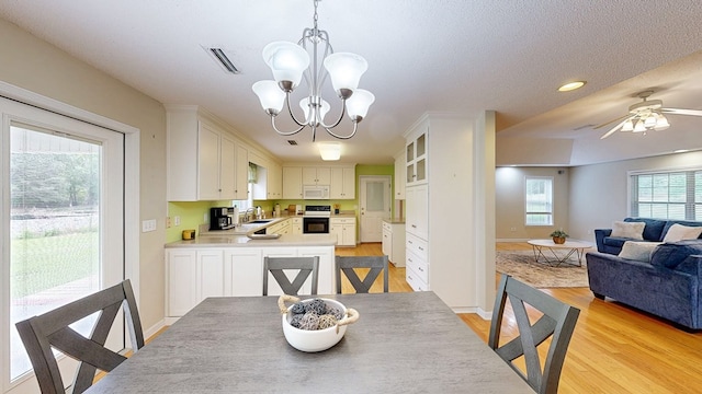 dining room featuring recessed lighting, ceiling fan with notable chandelier, light wood finished floors, baseboards, and visible vents