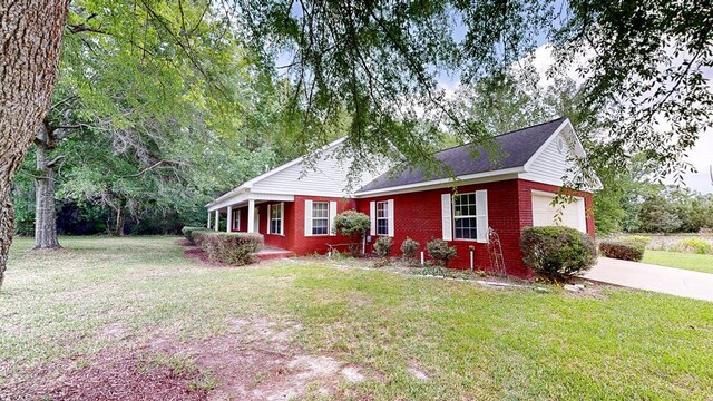 single story home featuring a front lawn, a garage, concrete driveway, and brick siding