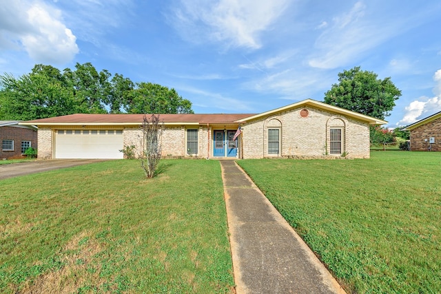 single story home with a front yard, brick siding, driveway, and an attached garage