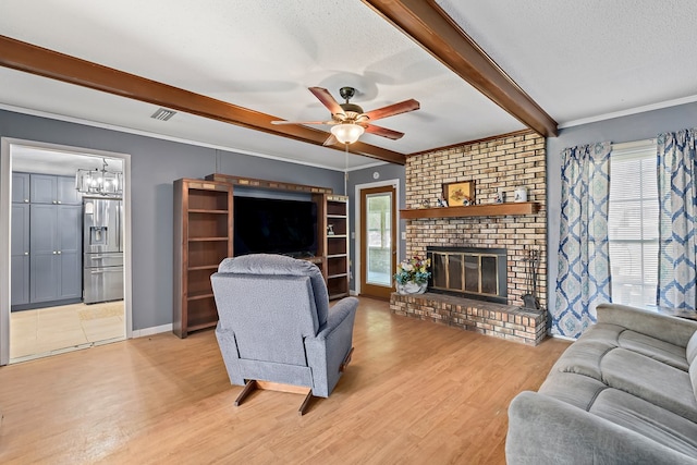 living area featuring beam ceiling, a fireplace, light wood-style floors, ornamental molding, and a textured ceiling