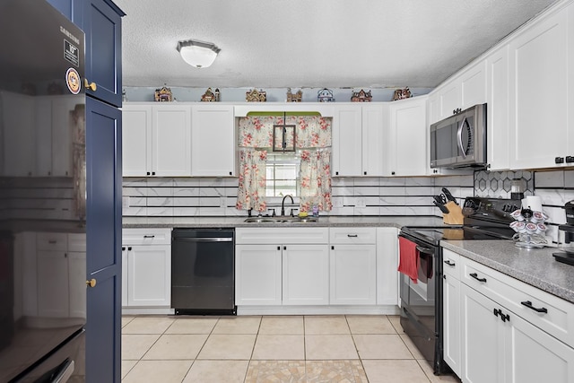 kitchen with light tile patterned floors, white cabinets, a sink, a textured ceiling, and black appliances