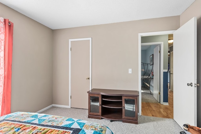 bedroom with light carpet and baseboards