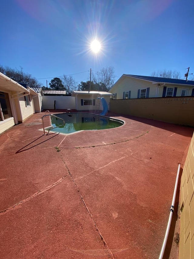 view of pool featuring a patio area and a water slide