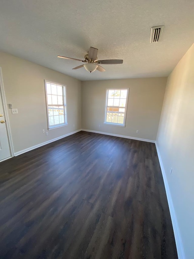 unfurnished room featuring a textured ceiling, ceiling fan, and dark wood-type flooring