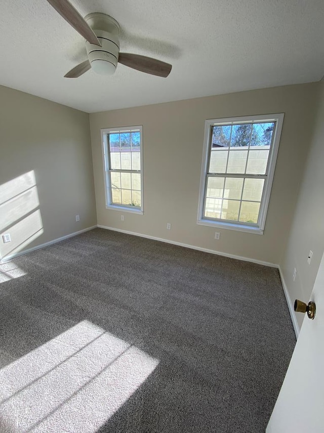 carpeted empty room with ceiling fan and a textured ceiling