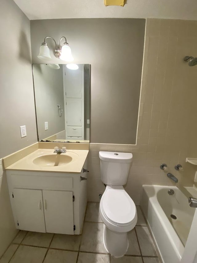 bathroom featuring tile patterned floors, vanity, tile walls, and toilet