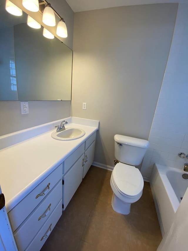 bathroom featuring toilet, vanity, tile patterned floors, and a bathing tub