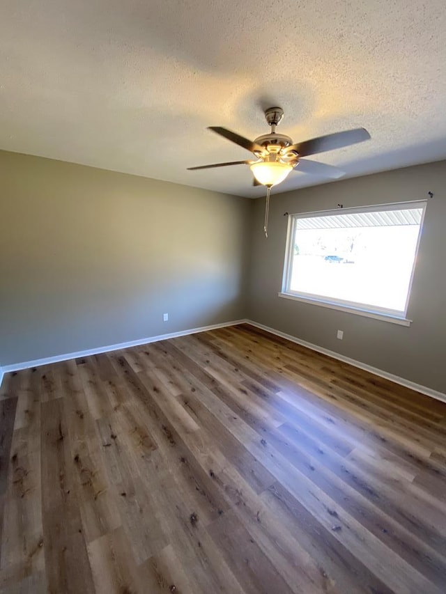 empty room with hardwood / wood-style flooring, ceiling fan, and a textured ceiling