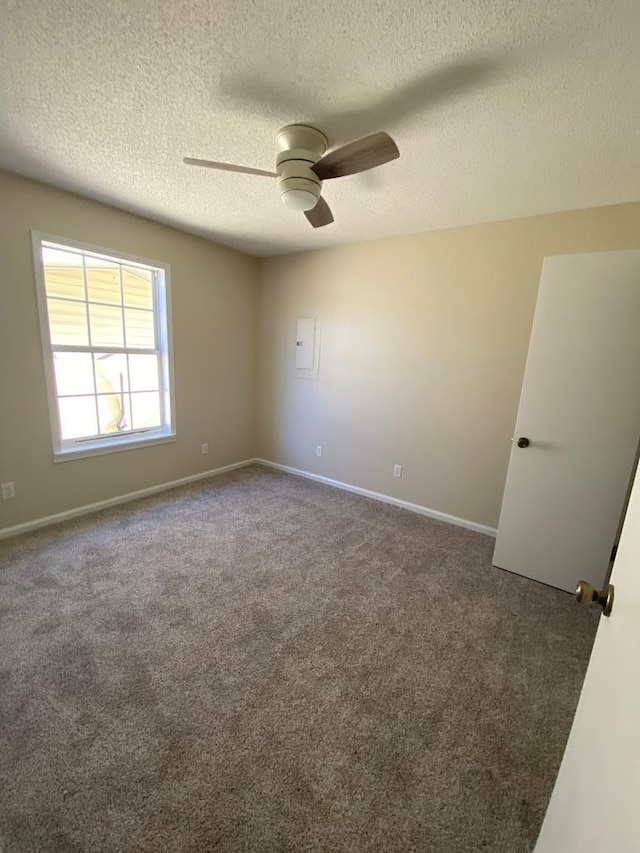 carpeted spare room with ceiling fan and a textured ceiling