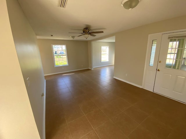 foyer entrance with ceiling fan and tile patterned flooring