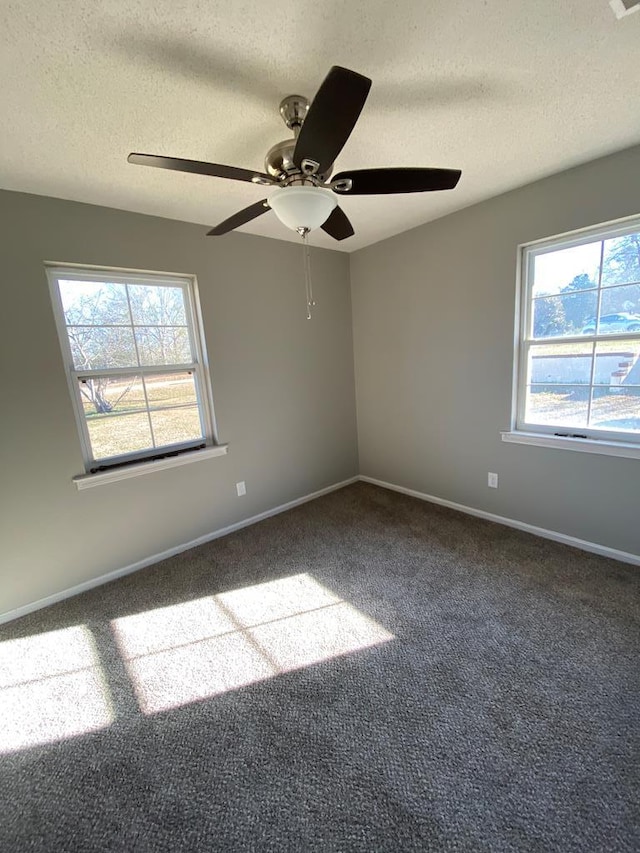 carpeted empty room featuring ceiling fan and a textured ceiling