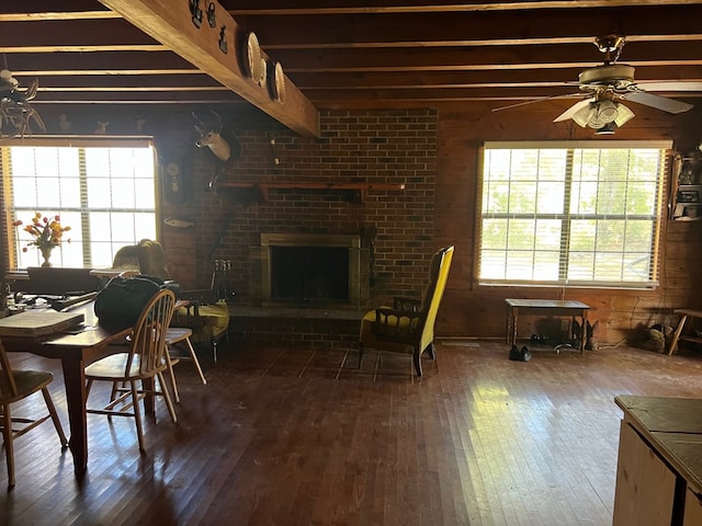 50 Holanna Rd, Morris, GA 39867 - living room with wood-type flooring, beam ceiling, ceiling fan, wood walls, and a brick fireplace
