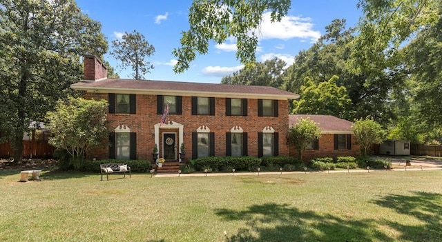 colonial inspired home featuring a front lawn