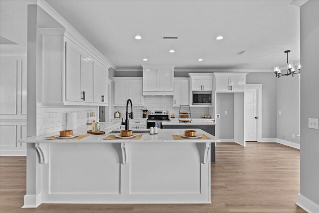 45 County Road 711, Enterprise, AL 36330 - kitchen featuring stainless steel appliances, a peninsula, a sink, light countertops, and white cabinets