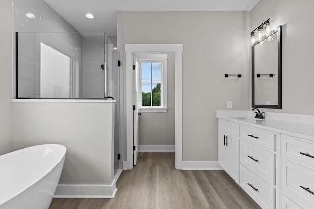 45 County Road 711, Enterprise, AL 36330 - full bathroom featuring baseboards, wood finished floors, tiled shower, vanity, and a freestanding tub