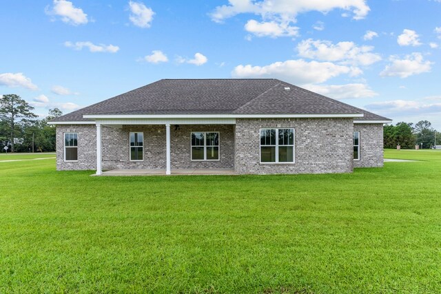 45 County Road 711, Enterprise, AL 36330 - back of property featuring roof with shingles, a patio, a lawn, and brick siding