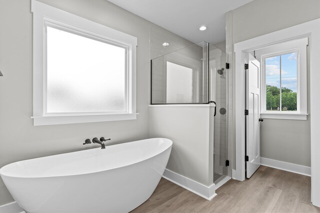 45 County Road 711, Enterprise, AL 36330 - full bathroom featuring a shower stall, wood finished floors, a freestanding bath, and baseboards
