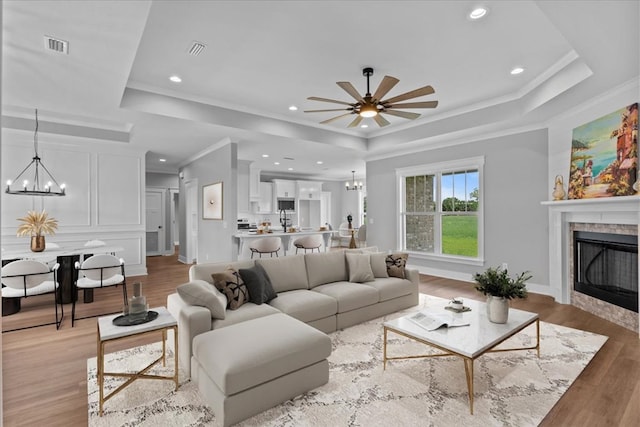 45 County Road 711, Enterprise, AL 36330 - living room with a tray ceiling, a chandelier, ornamental molding, light wood finished floors, and a fireplace