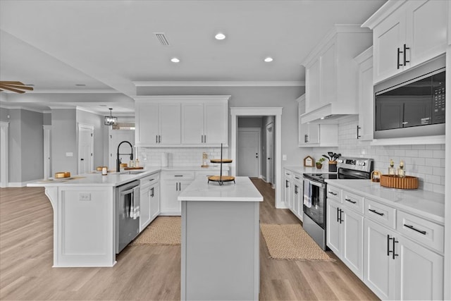 45 County Road 711, Enterprise, AL 36330 - kitchen with stainless steel appliances, a peninsula, ornamental molding, a sink, and light countertops