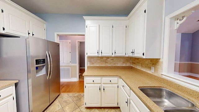 102 Eton Dr, Dothan, AL 36305 - kitchen featuring stainless steel refrigerator with ice dispenser, backsplash, white cabinets, light tile patterned floors, and a sink