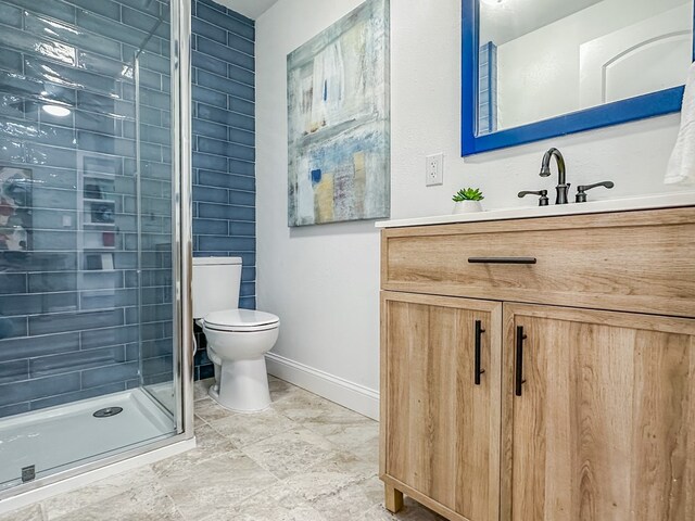 bathroom with vanity, a shower with shower door, and toilet