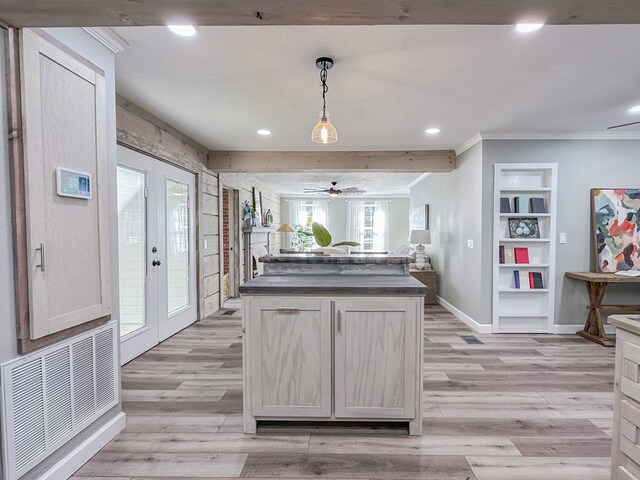 kitchen featuring crown molding, decorative light fixtures, light hardwood / wood-style floors, and built in shelves