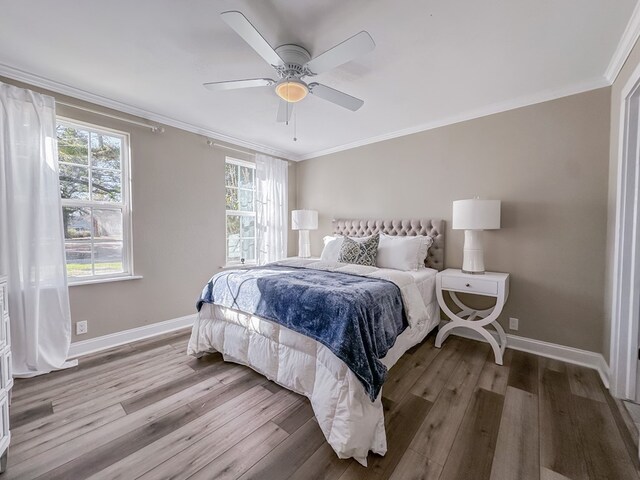 bedroom with ornamental molding, hardwood / wood-style floors, and ceiling fan