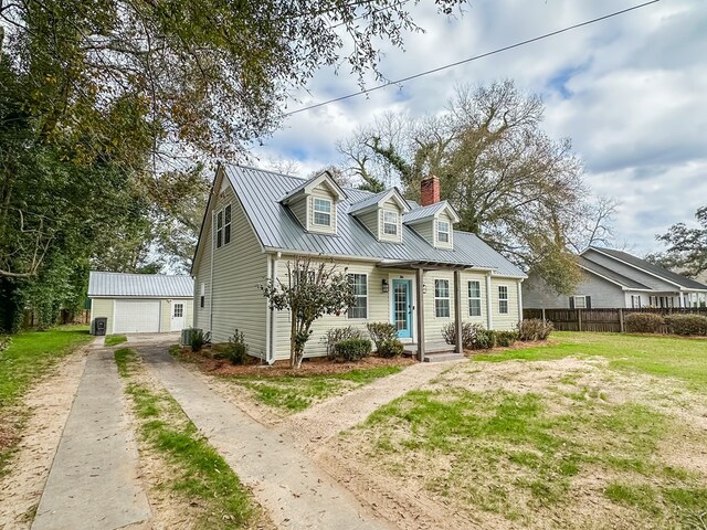 cape cod-style house with central AC unit, a garage, an outdoor structure, and a front yard