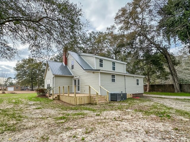 rear view of property with central AC and a wooden deck