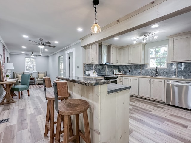 kitchen with electric range oven, decorative light fixtures, a kitchen breakfast bar, stainless steel dishwasher, and wall chimney exhaust hood