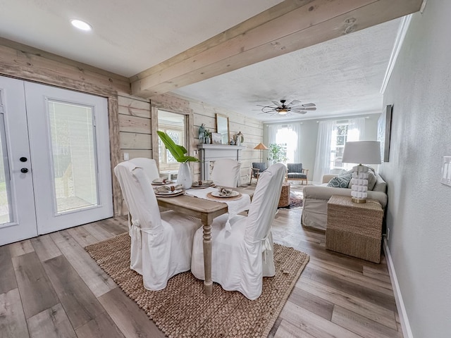 dining area with crown molding, ceiling fan, light hardwood / wood-style floors, a textured ceiling, and beamed ceiling