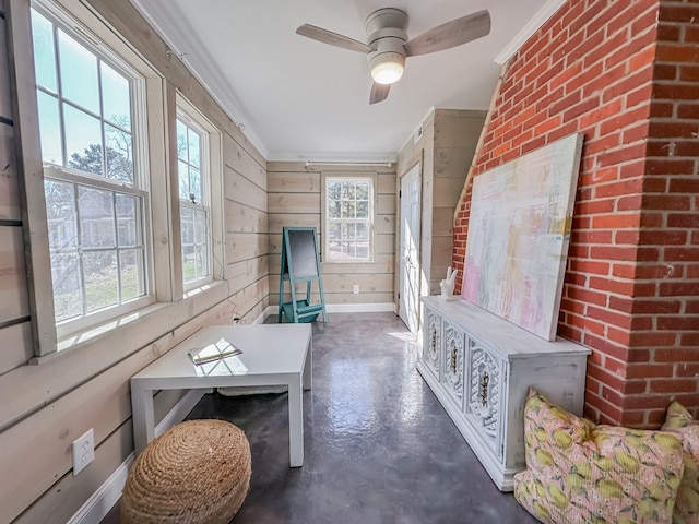 living room with wooden walls, ornamental molding, and brick wall