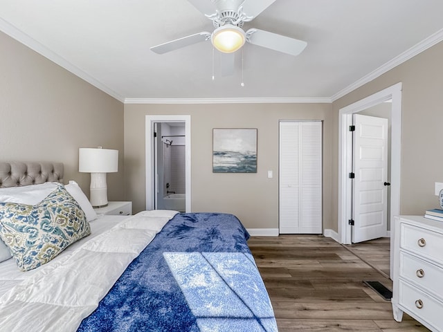 bedroom featuring connected bathroom, ornamental molding, ceiling fan, dark wood-type flooring, and a closet