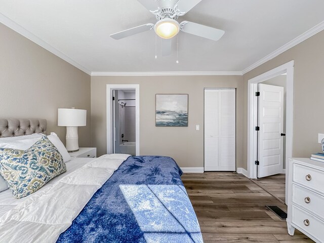 bedroom featuring connected bathroom, ornamental molding, ceiling fan, dark wood-type flooring, and a closet