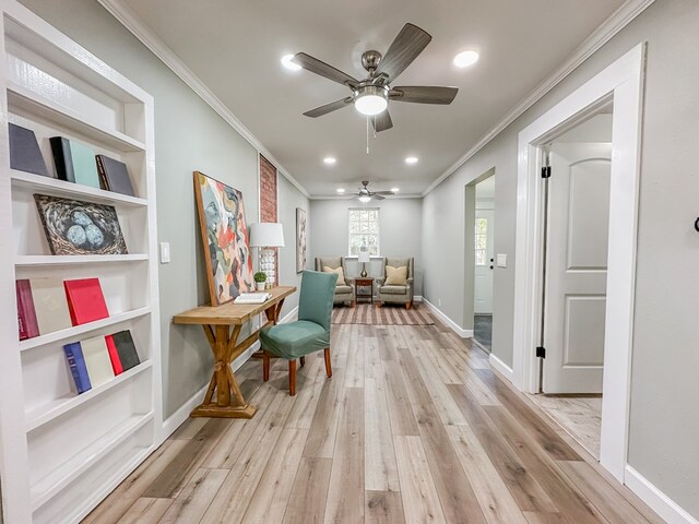 sitting room with ornamental molding, built in features, ceiling fan, and light wood-type flooring