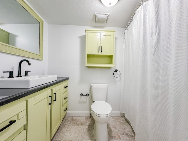 bathroom featuring vanity, a textured ceiling, and toilet