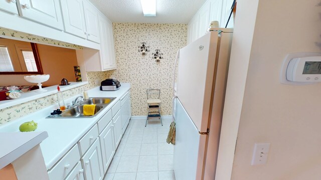 166 Candle Brook Dr, Dothan, AL 36303 - kitchen featuring freestanding refrigerator, a sink, white cabinetry, light tile patterned floors, and light countertops