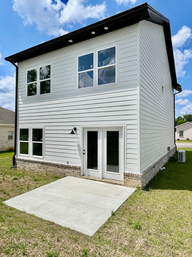 back of house with a yard and a patio
