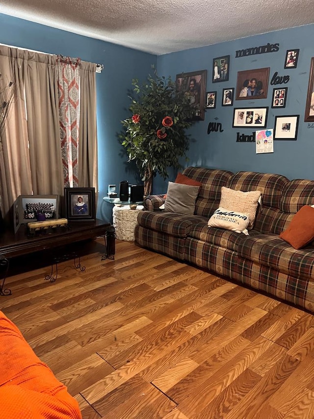 living room featuring wood-type flooring and a textured ceiling