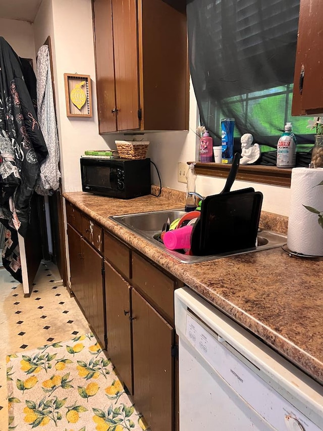 kitchen featuring dark brown cabinetry, sink, and dishwasher