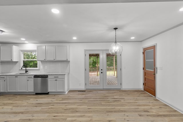1571 Denton Rd, Dothan, AL 36303 - kitchen with stainless steel dishwasher, french doors, decorative backsplash, white cabinets, and light wood-style flooring