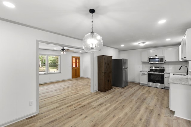 1571 Denton Rd, Dothan, AL 36303 - kitchen featuring stainless steel appliances, recessed lighting, light wood-style flooring, backsplash, and light stone countertops