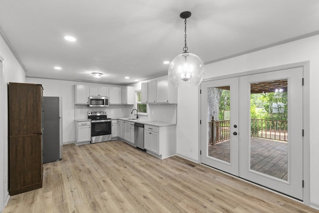 1571 Denton Rd, Dothan, AL 36303 - kitchen featuring appliances with stainless steel finishes, light wood-style floors, tasteful backsplash, recessed lighting, and french doors