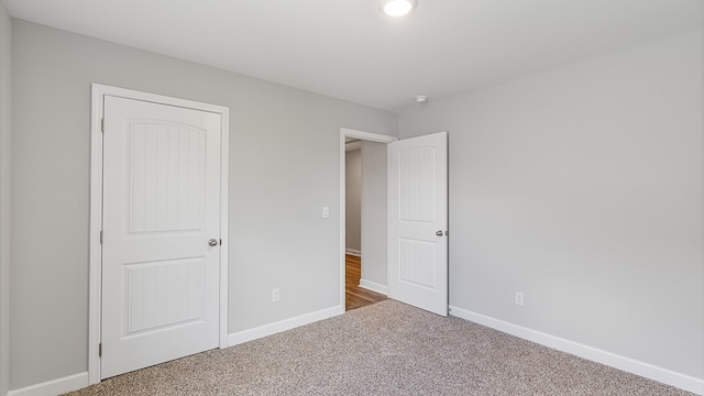 unfurnished bedroom featuring baseboards and carpet flooring