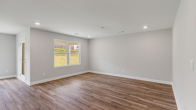 empty room featuring recessed lighting, wood finished floors, and baseboards