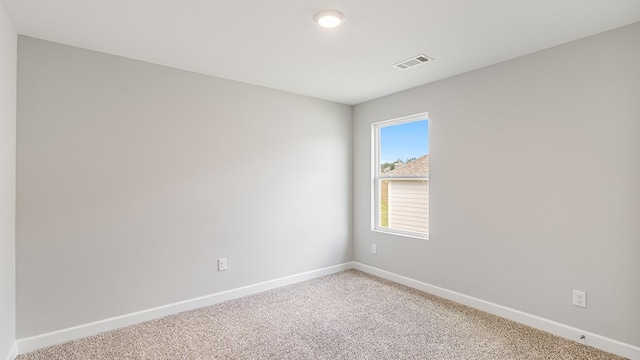 empty room featuring baseboards, visible vents, and light colored carpet