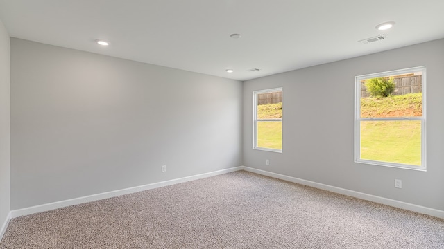 unfurnished room with light carpet, visible vents, baseboards, and recessed lighting