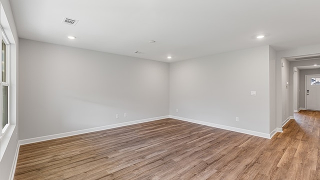 empty room featuring recessed lighting, wood finished floors, visible vents, and baseboards